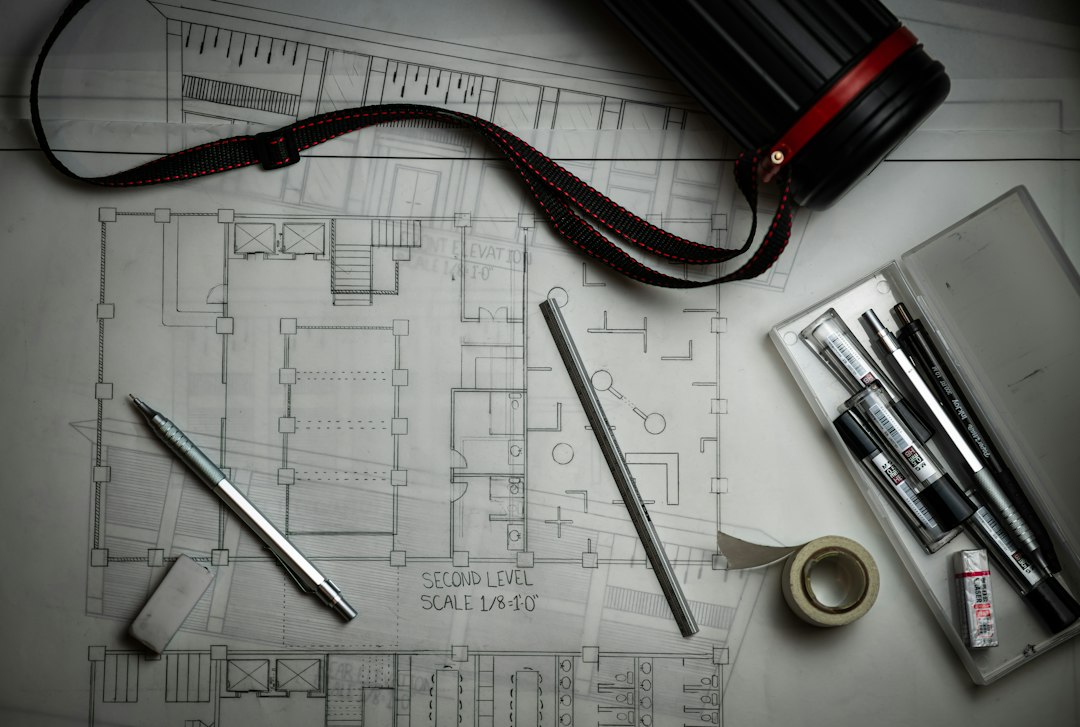 Architectural floor plans with drafting pencils, a ruler and a plan storage tube