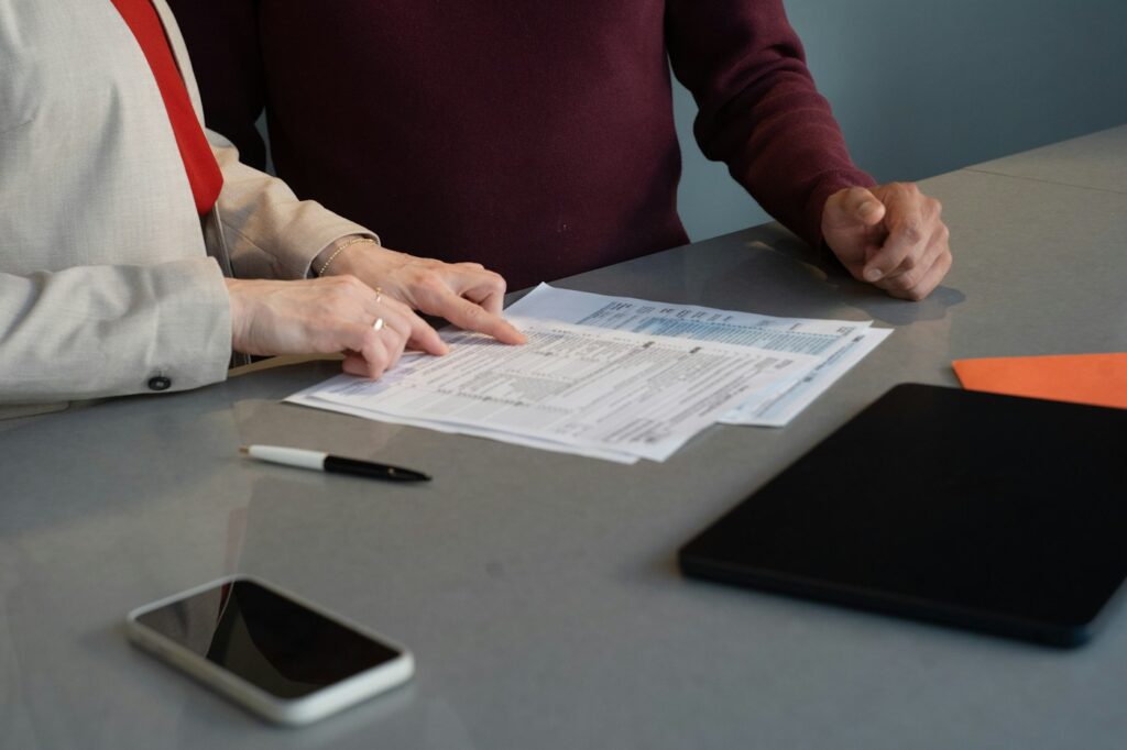 Two people reviewing financial paperwork together at a table