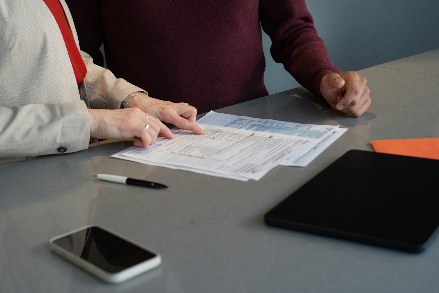 Two people reviewing financial paperwork together at a table
